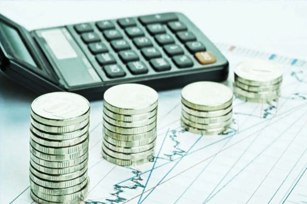 Calculadora y monedas que representan la gestión de tesorería en la asesoría para pymes