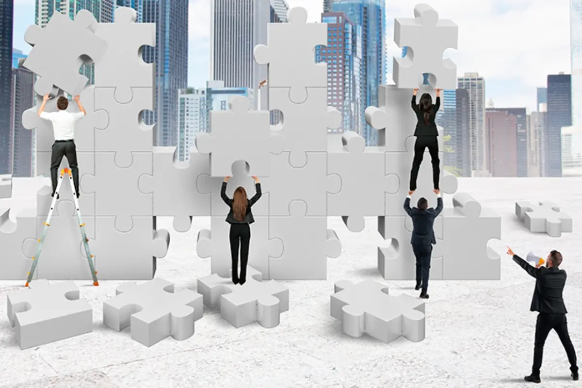 Equipo de personas completando el rompecabezas del paso a paso de como crear una empresa en colombia.